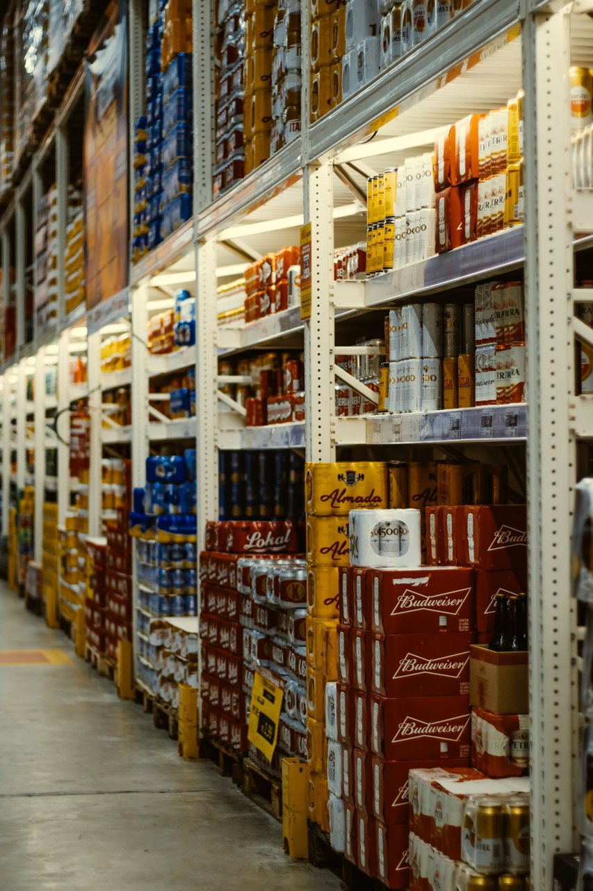 Free Rows of beer and beverages stacked neatly in a supermarket aisle. Stock Photo